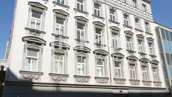 Historisches Mehrfamilienhaus mit klassischer Fassade und vielen Fenstern an einer Stadtstraße.