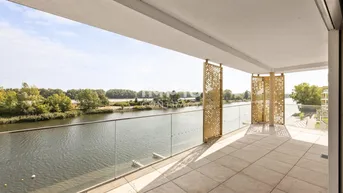 Großer Balkon mit Fliesenboden, Glasgeländer und weitem Blick auf den Fluss und die grüne Umgebung.