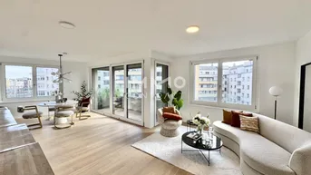 Helles, offenes Wohn- und Esszimmer mit modernem Design, Holzboden und Zugang zu einem Balkon.