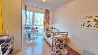 Freundliches Kinderzimmer mit Einzelbett, Schreibtisch und Blick ins Grüne.