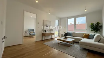 Helles Wohnzimmer mit modernem Sofa, Holzboden und Zugang zu einem Balkon.