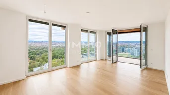 Helles Wohnzimmer mit Holzboden, großen Fenstern und weitem Blick über die Stadt und Natur.