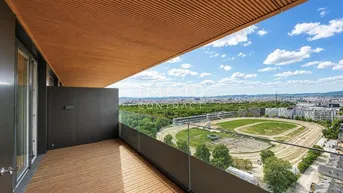Großer Balkon mit Holzboden und weitem Blick über die Stadt und die Rennbahn.