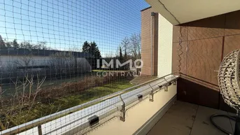 Sonniger Balkon mit Sicherheitsnetz und Blick auf den grünen Gartenbereich.