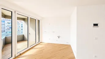Helles Wohnzimmer mit Holzboden und Zugang zu einem Balkon, ideal für moderne Einrichtung.