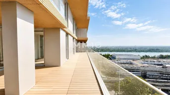 Große Terrasse mit Holzbelag und Glasgeländer bietet einen weiten Blick über die Stadt und das Wasser.