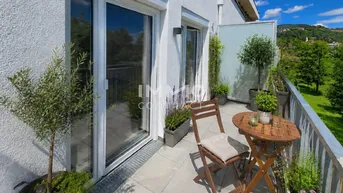 Gemütlicher Balkon mit Sitzgelegenheiten, Pflanzen und weitem Blick ins Grüne.