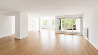 Helles, geräumiges Wohnzimmer mit Parkettboden und Zugang zu einem Balkon mit Blick ins Grüne.