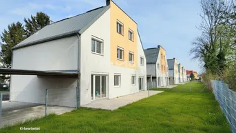 Moderne Reihenhäuser mit hellen Fassaden und kleinen Gärten in einer ruhigen Wohngegend.