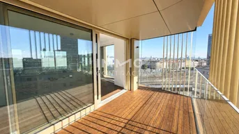 Geräumiger Balkon mit Holzboden und weitem Blick über die Stadt.
