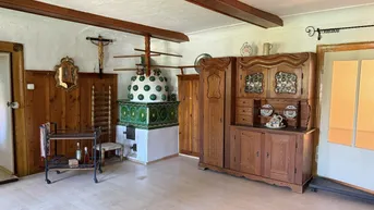 Geräumiger Wohnbereich mit traditionellem Kachelofen und rustikalen Holzmöbeln.