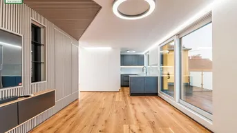 Offener Wohnbereich mit Holzboden, Zugang zur Terrasse und Blick auf die moderne Küche.