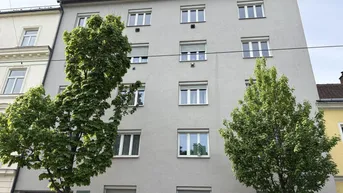 Die gepflegte Fassade eines Mehrfamilienhauses mit vielen Fenstern und Dachgauben.