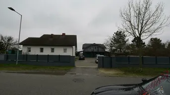 Ansicht der Immobilie von der Straße mit zwei Häusern und einer gepflasterten Einfahrt.