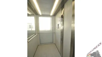 Heller Aufzug mit Edelstahl-Elementen und Fenster, bietet bequemen Zugang zu allen Etagen.
