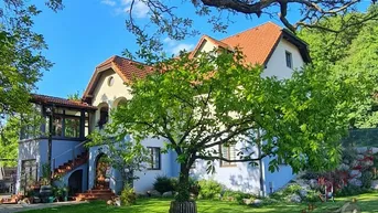 Charmantes Haus mit großem Garten, altem Baumbestand und traditioneller Architektur.