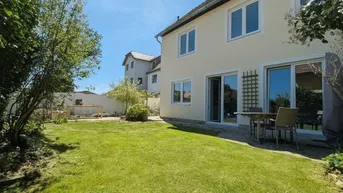 Gepflegter Gartenbereich mit Rasenfläche und einer kleinen Terrasse direkt am Haus.