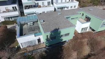 Luftaufnahme eines modernen Wohnkomplexes mit Flachdächern und begrünten Fassaden in einer Wohnsiedlung.