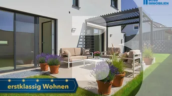 Moderne Terrasse mit bequemen Gartenmöbeln, Pergola und gepflegtem Rasenbereich hinter dem Haus.
