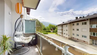 Balkon mit Hängesessel und weitem Blick auf die umliegende Berglandschaft.