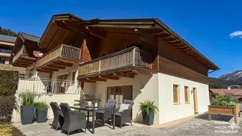 Charmantes Chalet mit traditioneller Holzfassade und gemütlicher Terrasse für entspannte Stunden im Freien.
