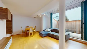 Heller Wohn-Essbereich mit modernem Sofa, Holzboden und Zugang zu einer privaten Terrasse.