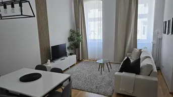 Helles Wohn- und Esszimmer mit modernem Design, Parkettboden und großen Fenstern.