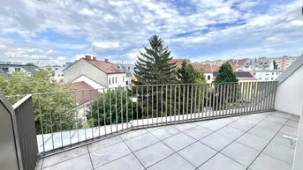 Große Dachterrasse mit Fliesenboden und Metallgeländer, bietet einen weiten Blick über die Stadt und Bäume.