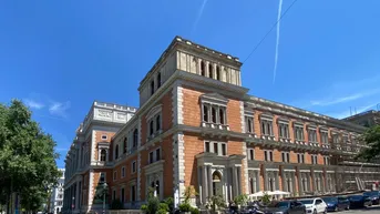 Historisches Gebäude mit beeindruckender Architektur und vielen Fenstern an einem sonnigen Tag.