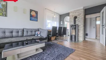 Gemütlicher Wohn-Essbereich mit Kaminofen, Holzboden und Essbereich.
