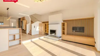 Helles Wohnzimmer mit modernem Kamin, integrierten Regalen und hellem Holzfußboden.