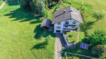 Luftaufnahme des Hauses mit Zufahrt, Garten und Photovoltaikanlage auf dem Grundstück.