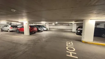 Geräumige Tiefgarage mit zahlreichen Stellplätzen und klarer Beschilderung für Hotelgäste.