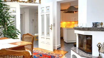 Gemütlicher Essbereich mit Kamin und Blick in die moderne Küche.