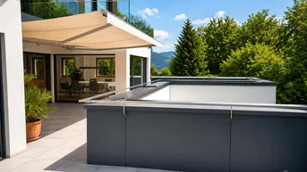 Große Sonnenterrasse mit ausfahrbarer Markise, Bergblick und moderner Architektur.