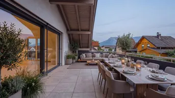 Großzügige, möblierte Terrasse mit Essbereich und Lounge-Möbeln, bietet einen weiten Blick auf die Berge.