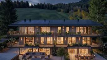Moderne Wohnanlage bei Nacht mit beleuchteten Innenräumen und gemütlichen Terrassenbereichen, umgeben von grüner Natur.