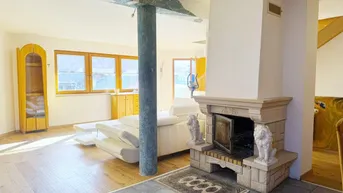 Wohnzimmer mit Kamin, Holzboden und Zugang zu einem Außenbereich.