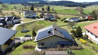 Drohnenaufnahme eines Hauses mit Solaranlage und weitem Blick über die ländliche Umgebung.