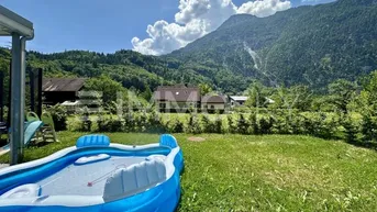 Großer Gartenbereich mit aufblasbarem Pool, Rasenfläche und beeindruckendem Bergblick.