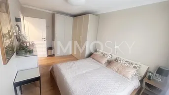 Helles Schlafzimmer mit Doppelbett, Einbauschränken und hellem Holzfußboden.