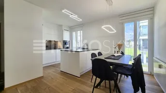 Moderner offener Wohn- und Essbereich mit integrierter Küche, Holzboden und Zugang zum Balkon.