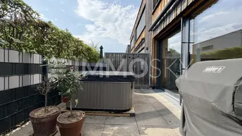 Geräumige Terrasse mit Whirlpool und Grillbereich, ideal für Entspannung im Freien und gesellige Stunden.