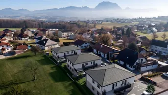 Luftaufnahme einer Wohnsiedlung mit Neubauten und malerischem Bergblick im Salzkammergut.