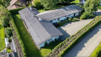 Luftaufnahme des L-förmigen Gebäudes mit gepflegter Hecke und grüner Umgebung.
