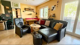Geräumiger Wohn- und Essbereich mit bequemer Ledercouch, Esstisch und Fliesenboden.