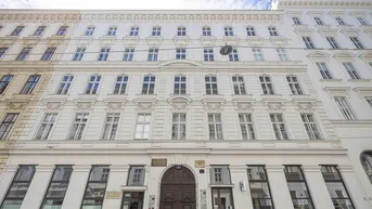 Klassische Altbaufassade mit vielen Fenstern und historischem Eingangstor in der Stadt.