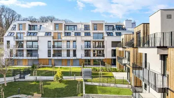Moderne Wohngebäude mit weißer Fassade, Holzverkleidung und begrünten Außenanlagen unter blauem Himmel.