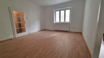 Helles Zimmer mit Laminatboden und weiß gestrichenen Wänden, bereit für die individuelle Gestaltung.