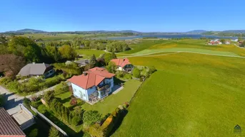Luftaufnahme des Anwesens mit weitem Blick über die Landschaft und einen See.
